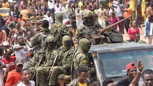 People celebrate in the streets with members of Guinea's armed forces after the arrest of Guinea's president, Alpha Conde, in a coup d'etat in Conakry, September 5, 2021. - Guinean special forces seized power in a coup on September 5, arresting the president and imposing an indefinite curfew in the poor west African country. "We have decided, after having taken the president, to dissolve the constitution," said a uniformed officer flanked by soldiers toting assault rifles in a video sent to AFP.