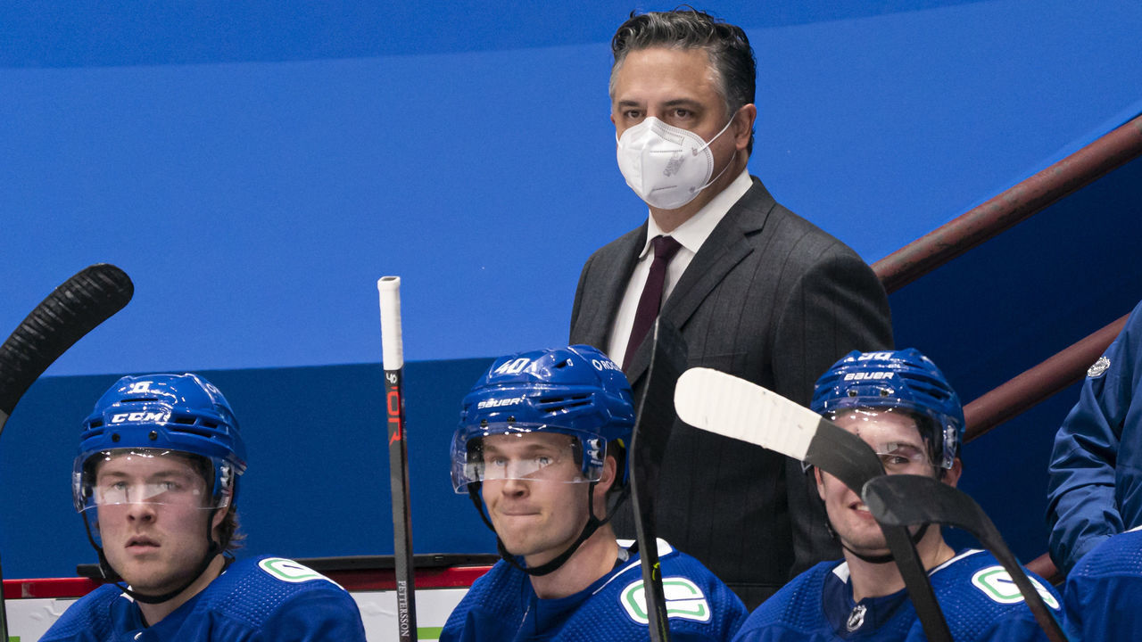 VANCOUVER, BC - FEBRUARY 13: Head coach Travis Green of the Vancouver Canucks behind the bench with players Brock Boeser #6, Elias Pettersson #40 and Nils Hoglander #36 during NHL hockey action against the Calgary Flames at Rogers Arena on February 13, 2021 in Vancouver, Canada.