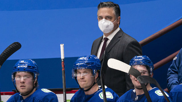 VANCOUVER, BC - FEBRUARY 13: Head coach Travis Green of the Vancouver Canucks behind the bench with players Brock Boeser #6, Elias Pettersson #40 and Nils Hoglander #36 during NHL hockey action against the Calgary Flames at Rogers Arena on February 13, 2021 in Vancouver, Canada.
