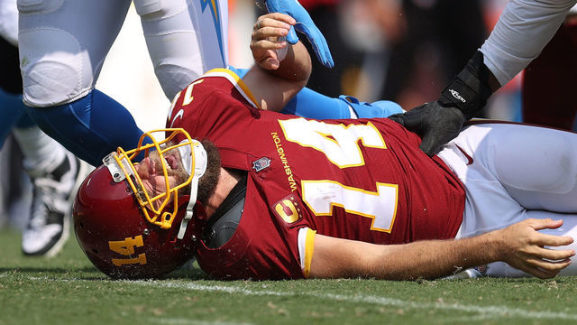 LANDOVER, MARYLAND - SEPTEMBER 12: Ryan Fitzpatrick #14 of the Washington Football Team reacts after taking a hit against the Los Angeles Chargers during the second quarter at FedExField on September 12, 2021 in Landover, Maryland.