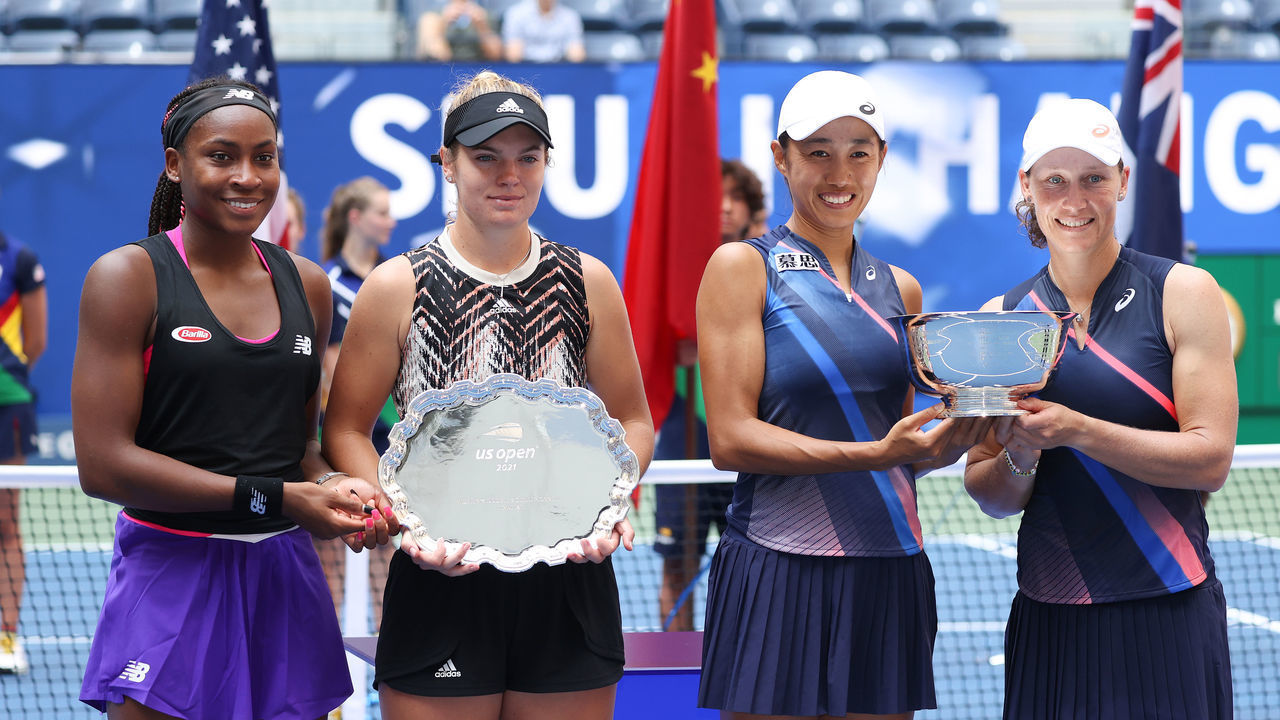 NEW YORK, NEW YORK - SEPTEMBER 12: (L-R) Coco Gauff of the United States and Catherine McNally of the United States smile with the runner-up trophy alongside Shuai Zhang of China and Samantha Stosur of Australia who celebrate with the championship trophy after their Women's Doubles final match on Day Fourteen of the 2021 US Open at the USTA Billie Jean King National Tennis Center on September 12, 2021 in the Flushing neighborhood of the Queens borough of New York City.
