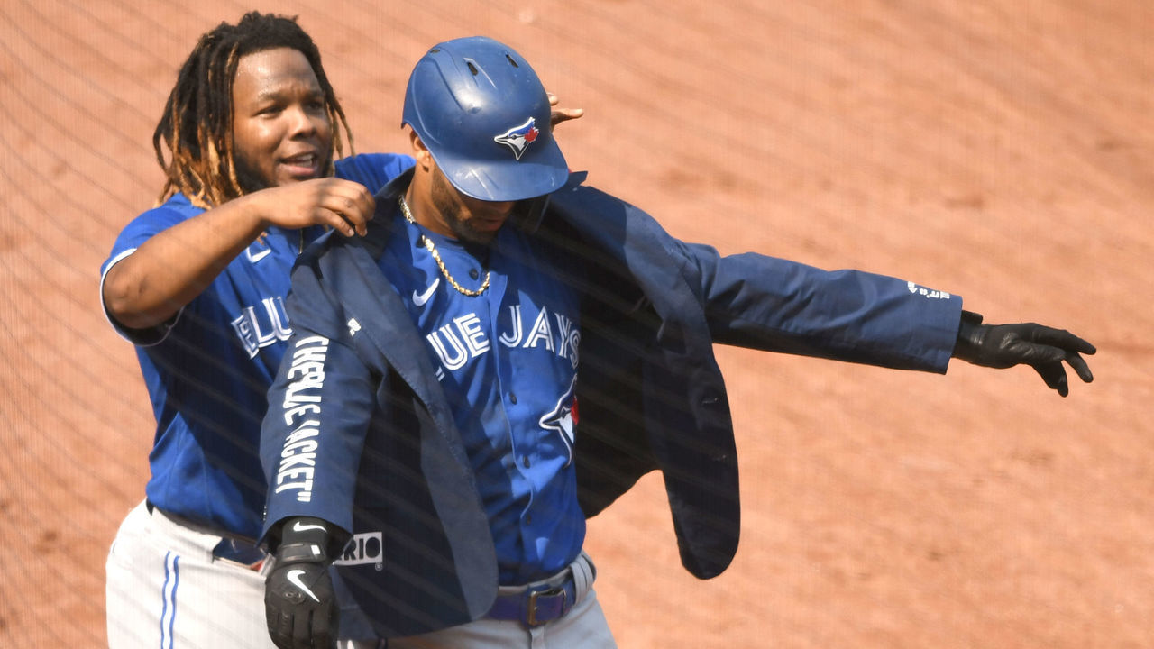 BALTIMORE, MD - SEPTEMBER 12: Vladimir Guerrero Jr. #27 of the Toronto Blue Jays puts the home run jacket on Lourdes Gurriel Jr. #13 of the Toronto Blue Jays after hitting a two-run home run in the fifth inning during a baseball game against the Baltimore Orioles at Oriole Park at Camden Yards on September 12, 2021 in Baltimore, Maryland.