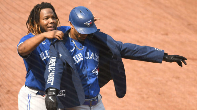 BALTIMORE, MD - SEPTEMBER 12: Vladimir Guerrero Jr. #27 of the Toronto Blue Jays puts the home run jacket on Lourdes Gurriel Jr. #13 of the Toronto Blue Jays after hitting a two-run home run in the fifth inning during a baseball game against the Baltimore Orioles at Oriole Park at Camden Yards on September 12, 2021 in Baltimore, Maryland.