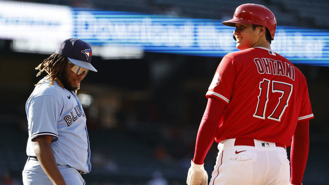 ANAHEIM, CALIFORNIA - AUGUST 10: Shohei Ohtani #17 of the Los Angeles Angels and Vladimir Guerrero Jr. #27 of the Toronto Blue Jays react while on first base during the sixth inning of game one of a doubleheader at Angel Stadium of Anaheim on August 10, 2021 in Anaheim, California.