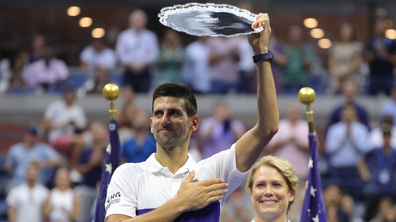 Serbia's Novak Djokovic holds his trophy after losing the 2021 US Open Tennis tournament men's final match against Russia's Daniil Medvedev (R) and at the USTA Billie Jean King National Tennis Center in New York, on September 12, 2021.