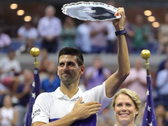 Serbia's Novak Djokovic holds his trophy after losing the 2021 US Open Tennis tournament men's final match against Russia's Daniil Medvedev (R) and at the USTA Billie Jean King National Tennis Center in New York, on September 12, 2021.