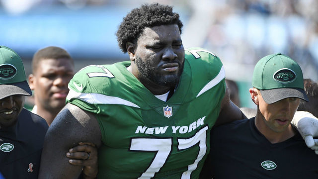CHARLOTTE, NORTH CAROLINA - SEPTEMBER 12: Mekhi Becton #77 of the New York Jets is helped off the field after being injured during the third quarter against the Carolina Panthers at Bank of America Stadium on September 12, 2021 in Charlotte, North Carolina.
