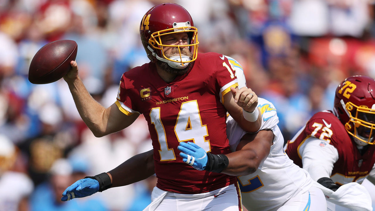 LANDOVER, MARYLAND - SEPTEMBER 12: Ryan Fitzpatrick #14 of the Washington Football Team takes a hit against the Los Angeles Chargers during the second quarter at FedExField on September 12, 2021 in Landover, Maryland.