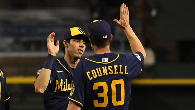 PHOENIX, ARIZONA - JUNE 22: Christian Yelich #22 and manager Craig Counsell #30 of the Milwaukee Brewers celebrate a 5-0 win against the Arizona Diamondbacks at Chase Field on June 22, 2021 in Phoenix, Arizona.