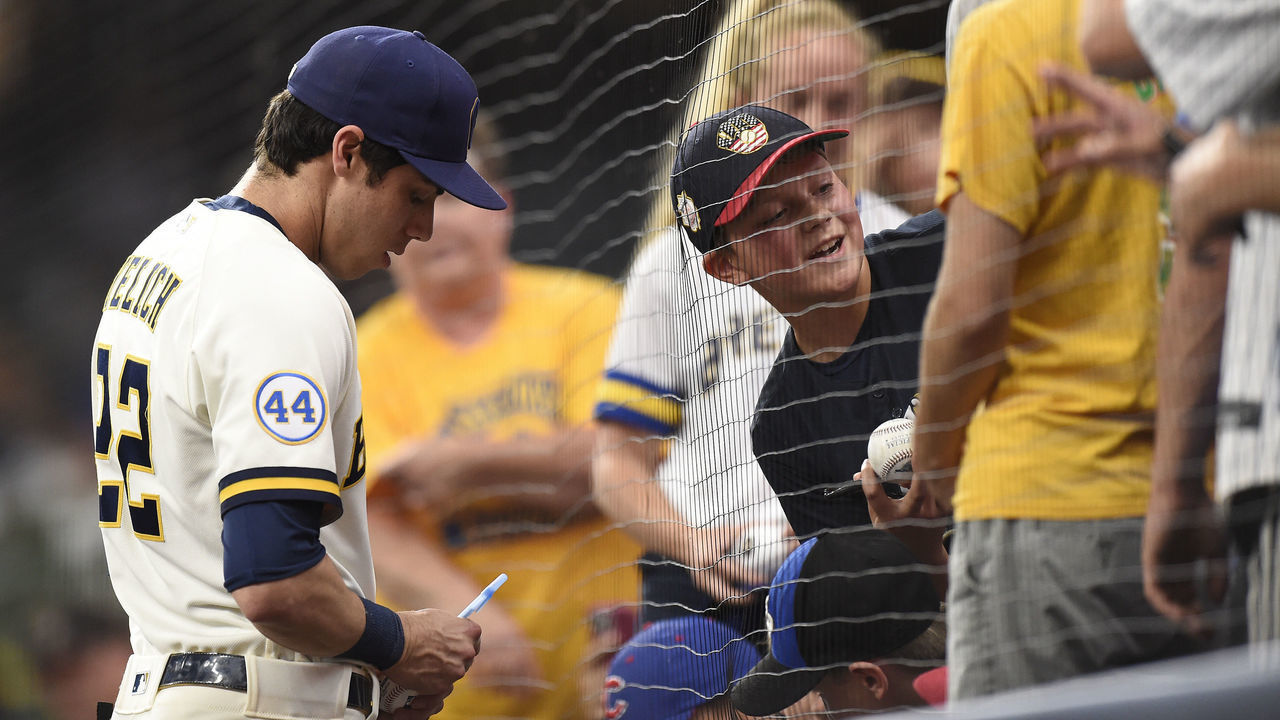 MILWAUKEE, WISCONSIN - JUNE 29: Christian Yelich #22 of the Milwaukee Brewers signs autographs for fans before a game against the Chicago Cubs at American Family Field on June 29, 2021 in Milwaukee, Wisconsin.