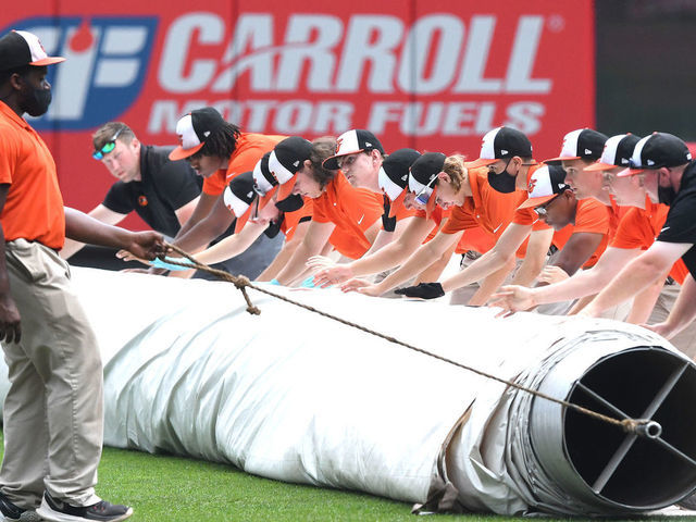 BALTIMORE, MD - AUGUST 11: The Baltimore Orioles grounds crew covers the field before it starts to rain at a baseball game against the Detroit Tigers at Oriole Park at Camden Yards on August 11, 2021 in Baltimore, Maryland.