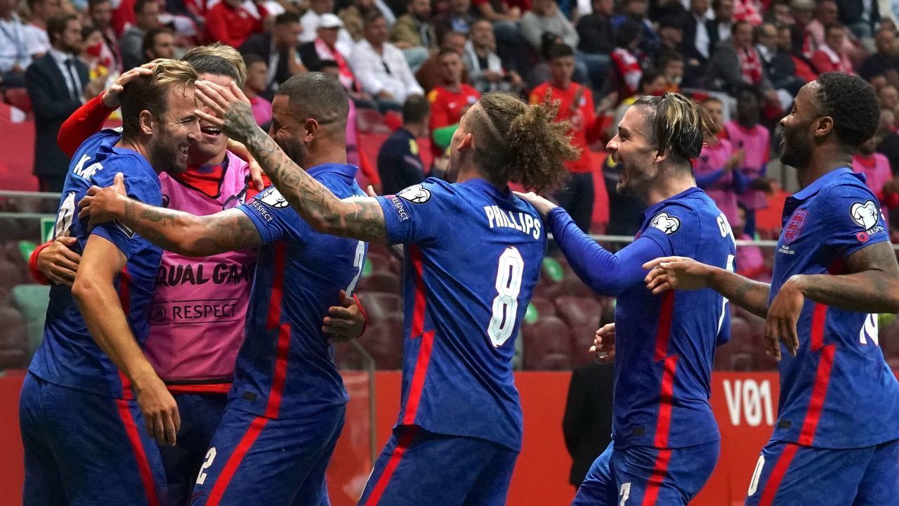 TOPSHOT - England's forward Harry Kane (1stL) is celebrated by teammates after scoring the 0-1 goal during the FIFA World Cup Qatar 2022 qualification Group I football match between Poland and England in Warsaw, on September 8, 2021.