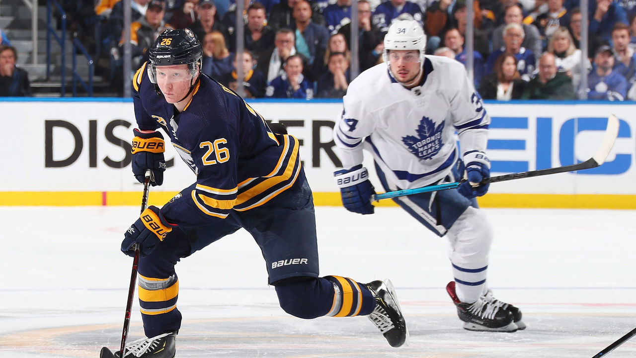 BUFFALO, NY - DECEMBER 4: Rasmus Dahlin #26 of the Buffalo Sabres skates with the puck against Auston Matthews #34 of the Toronto Maple Leafs during an NHL game on December 4, 2018 at KeyBank Center in Buffalo, New York.