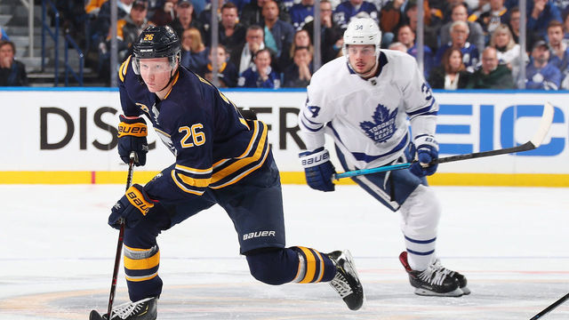 BUFFALO, NY - DECEMBER 4: Rasmus Dahlin #26 of the Buffalo Sabres skates with the puck against Auston Matthews #34 of the Toronto Maple Leafs during an NHL game on December 4, 2018 at KeyBank Center in Buffalo, New York.