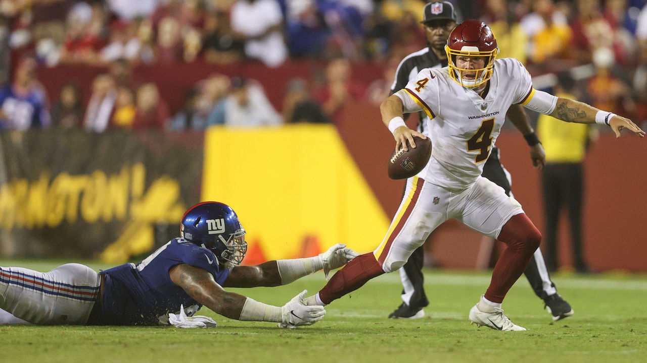 LANDOVER, MARYLAND - SEPTEMBER 16: Taylor Heinicke #4 of the Washington Football Team rushes from Leonard Williams #99 of the New York Giants during the third quarter at FedExField on September 16, 2021 in Landover, Maryland.