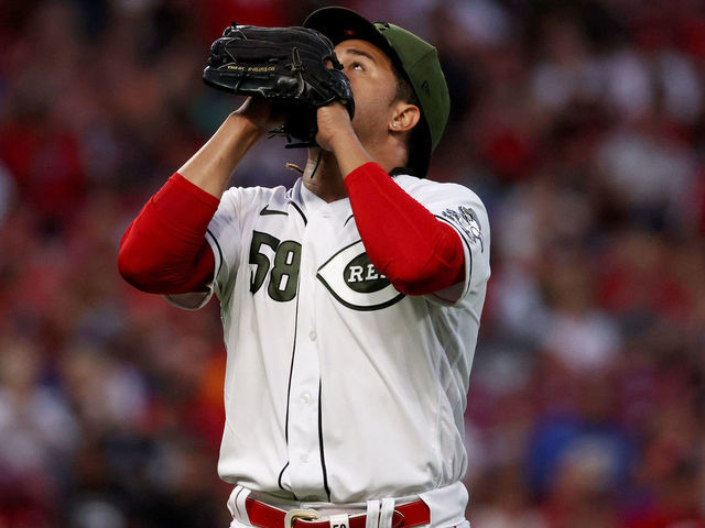 Cincinnati Reds' Kyle Farmer (17) reacts after being hit by a