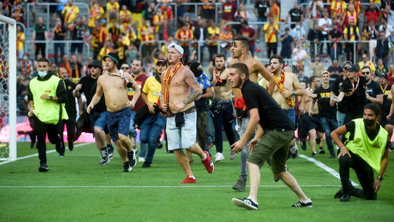 Lens' supporters invade the pitch during the French L1 football match between RC Lens (RCL) and Lille (LOSC) at Stade Bollaert-Delelis in Lens, northern France, on September 18, 2021.