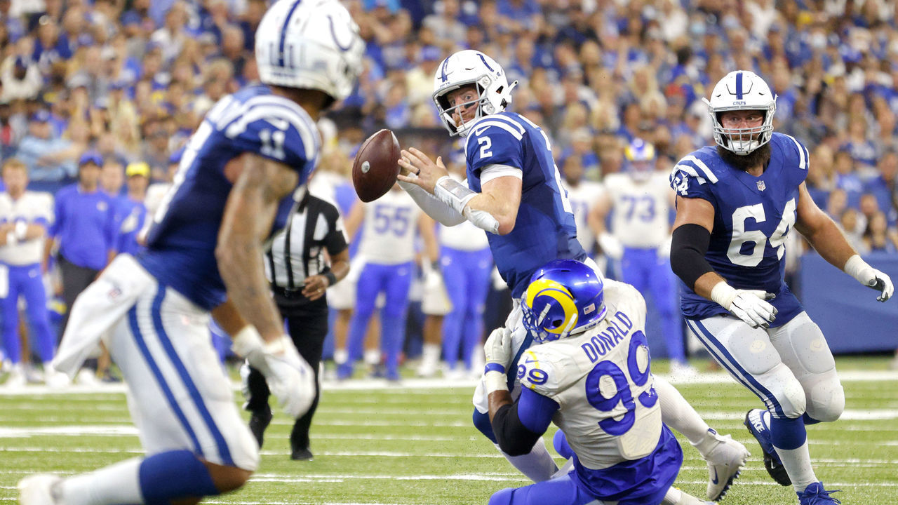 INDIANAPOLIS, INDIANA - SEPTEMBER 19: Quarterback Carson Wentz #2 of the Indianapolis Colts looks to throw the ball while being tackled by defensive end Aaron Donald #99 of the Los Angeles Rams in the game at Lucas Oil Stadium on September 19, 2021 in Indianapolis, Indiana.