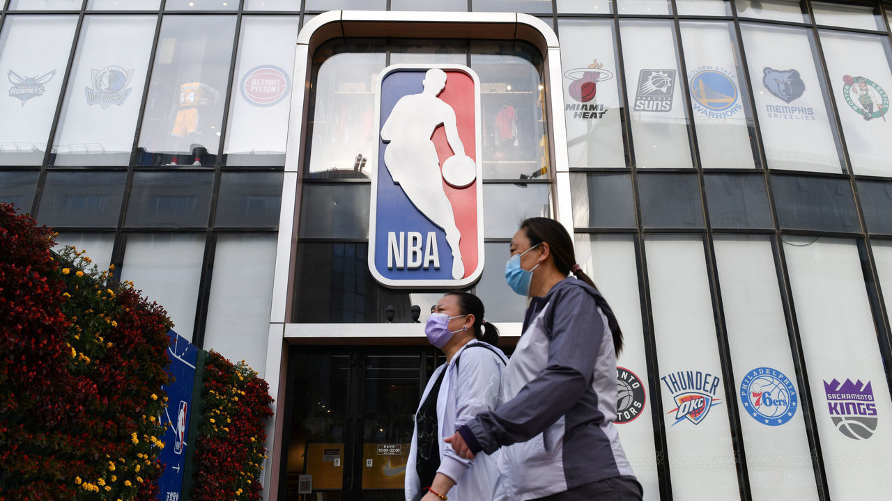 BEIJING, CHINA - 2021/05/10: Women walk past the NBA logo and store on Wangfujing Street in Beijing.