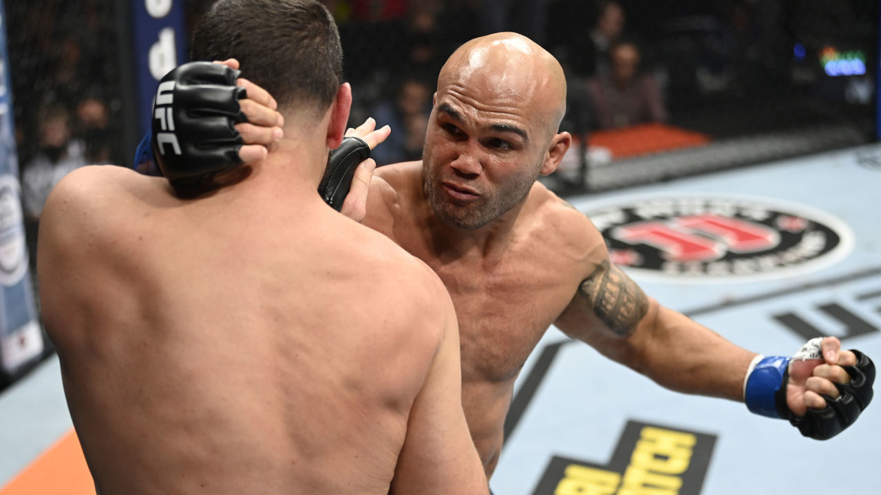 LAS VEGAS, NEVADA - SEPTEMBER 25: (R-L) Robbie Lawler punches Nick Diaz in their middleweight fight during the UFC 266 event on September 25, 2021 in Las Vegas, Nevada.