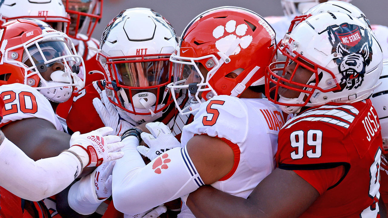 RALEIGH, NORTH CAROLINA - SEPTEMBER 25: Daniel Joseph #99 of the North Carolina State Wolfpack tackles D.J. Uiagalelei #5 of the Clemson Tigers during the first half of their game at Carter-Finley Stadium on September 25, 2021 in Raleigh, North Carolina.