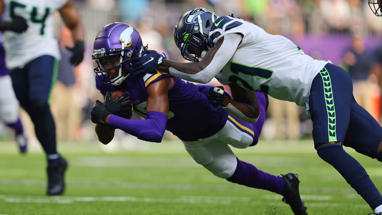MINNEAPOLIS, MINNESOTA - SEPTEMBER 26: Justin Jefferson #18 of the Minnesota Vikings catches the ball during the first half and is tackled by Tre Flowers #21 of the Seattle Seahawks at U.S. Bank Stadium on September 26, 2021 in Minneapolis, Minnesota.