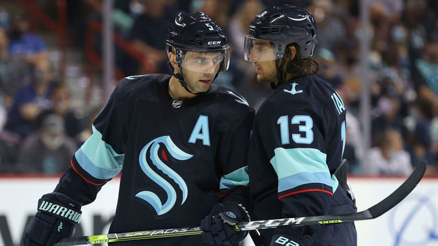 SPOKANE, WASHINGTON - SEPTEMBER 26: Mark Giordano #5 and Brandon Tanev #13 of the Seattle Kraken talk in the second period against the Vancouver Canucks during a preseason game at Spokane Veterans Memorial Arena on September 26, 2021 in Spokane, Washington.