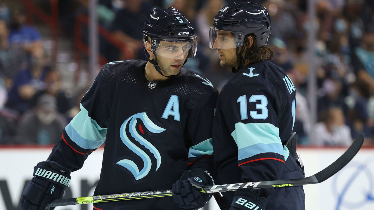 SPOKANE, WASHINGTON - SEPTEMBER 26: Mark Giordano #5 and Brandon Tanev #13 of the Seattle Kraken talk in the second period against the Vancouver Canucks during a preseason game at Spokane Veterans Memorial Arena on September 26, 2021 in Spokane, Washington.