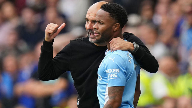 LONDON, ENGLAND - SEPTEMBER 25: Pep Guardiola, Manager of Manchester City speaks with player Raheem Sterling during the Premier League match between Chelsea and Manchester City at Stamford Bridge on September 25, 2021 in London, England.