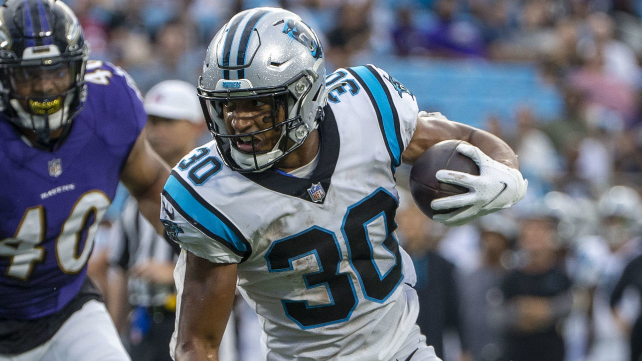 CHARLOTTE, NC - AUGUST 21: Chuba Hubbard #30 of the Carolina Panthers runs the ball against DeShon Elliott #32 of the Baltimore Ravens during the first half of a NFL preseason game at Bank of America Stadium on August 21, 2021 in Charlotte, North Carolina.