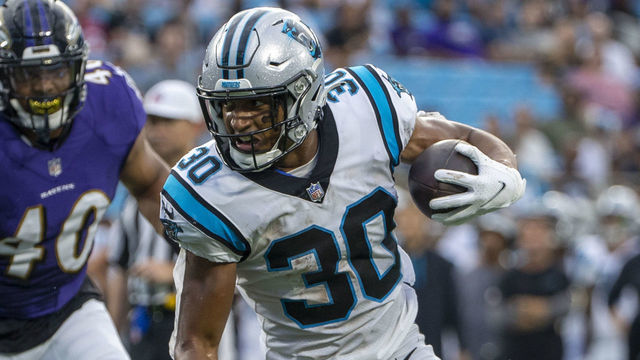 CHARLOTTE, NC - AUGUST 21: Chuba Hubbard #30 of the Carolina Panthers runs the ball against DeShon Elliott #32 of the Baltimore Ravens during the first half of a NFL preseason game at Bank of America Stadium on August 21, 2021 in Charlotte, North Carolina.