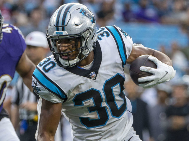 CHARLOTTE, NC - AUGUST 21: Chuba Hubbard #30 of the Carolina Panthers runs the ball against DeShon Elliott #32 of the Baltimore Ravens during the first half of a NFL preseason game at Bank of America Stadium on August 21, 2021 in Charlotte, North Carolina.