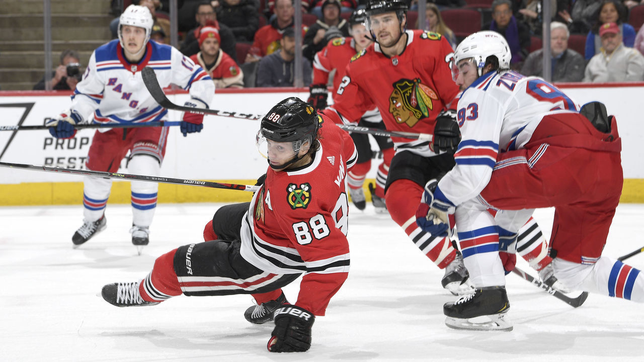 CHICAGO, IL - FEBRUARY 19: Patrick Kane #88 of the Chicago Blackhawks loses his footing in front of Mika Zibanejad #93 of the New York Rangers in the third period at the United Center on February 19, 2020 in Chicago, Illinois.