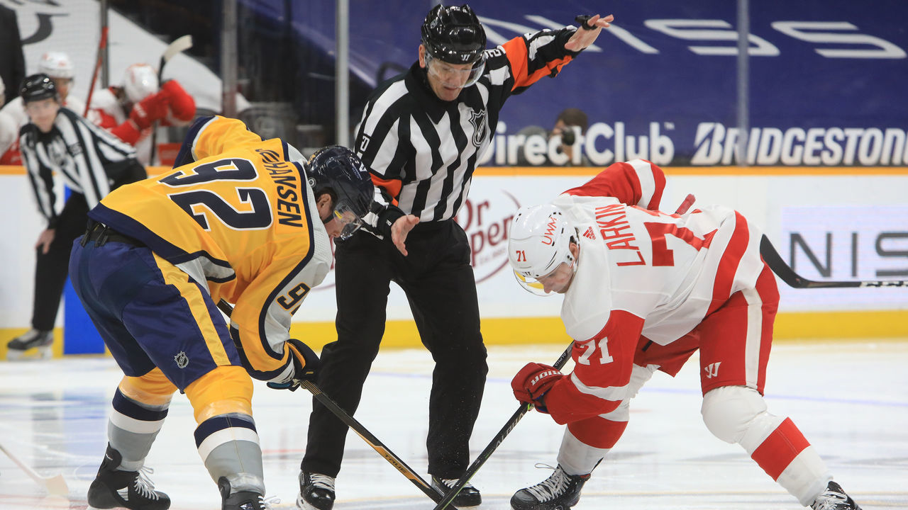 NASHVILLE, TN - MARCH 23: Referee Tim Peel (20) drops the puck for the opening faceoff between Nashville Predators center Ryan Johansen (92) and Detroit Red Wings center Dylan Larkin (71) during the NHL game between the Nashville Predators and Detroit Red Wings, held on March 23, 2021, at Bridgestone Arena in Nashville, Tennessee.