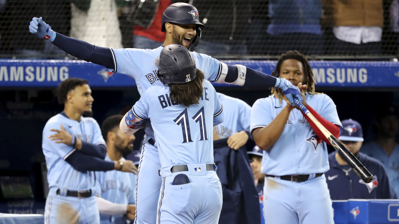 TORONTO, ON - September 29 Toronto Blue Jays shortstop Bo Bichette (11) comes home after his solo homer in the 8th and celebrates as he holds up left fielder Lourdes Gurriel Jr. (13). This was Bichette's second homer of the game and the game winner. The Toronto Blue Jays beat the New York Yankees 6-5 at The Rogers Centre in MLB baseball action. As the season winds down, the two teams are vying for a playoff spot. September 29 2021 (Richard Lautens/Toronto Star via Getty Images)