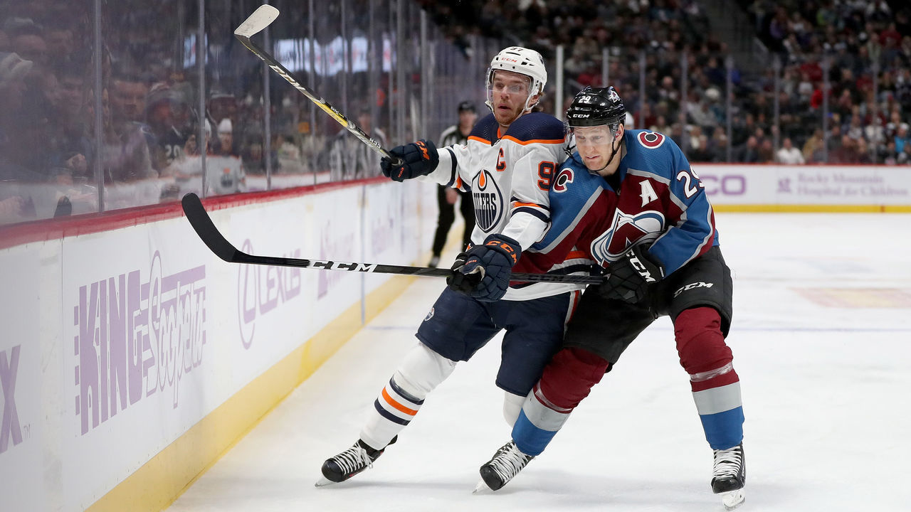 DENVER, COLORADO - NOVEMBER 27: Connor McDavid #97 of the Edmonton Oilers fights for the puck against Nathan MacKinnon #29 of the Colorado Avalanche in the first period at the Pepsi Center on November 27, 2019 in Denver, Colorado.