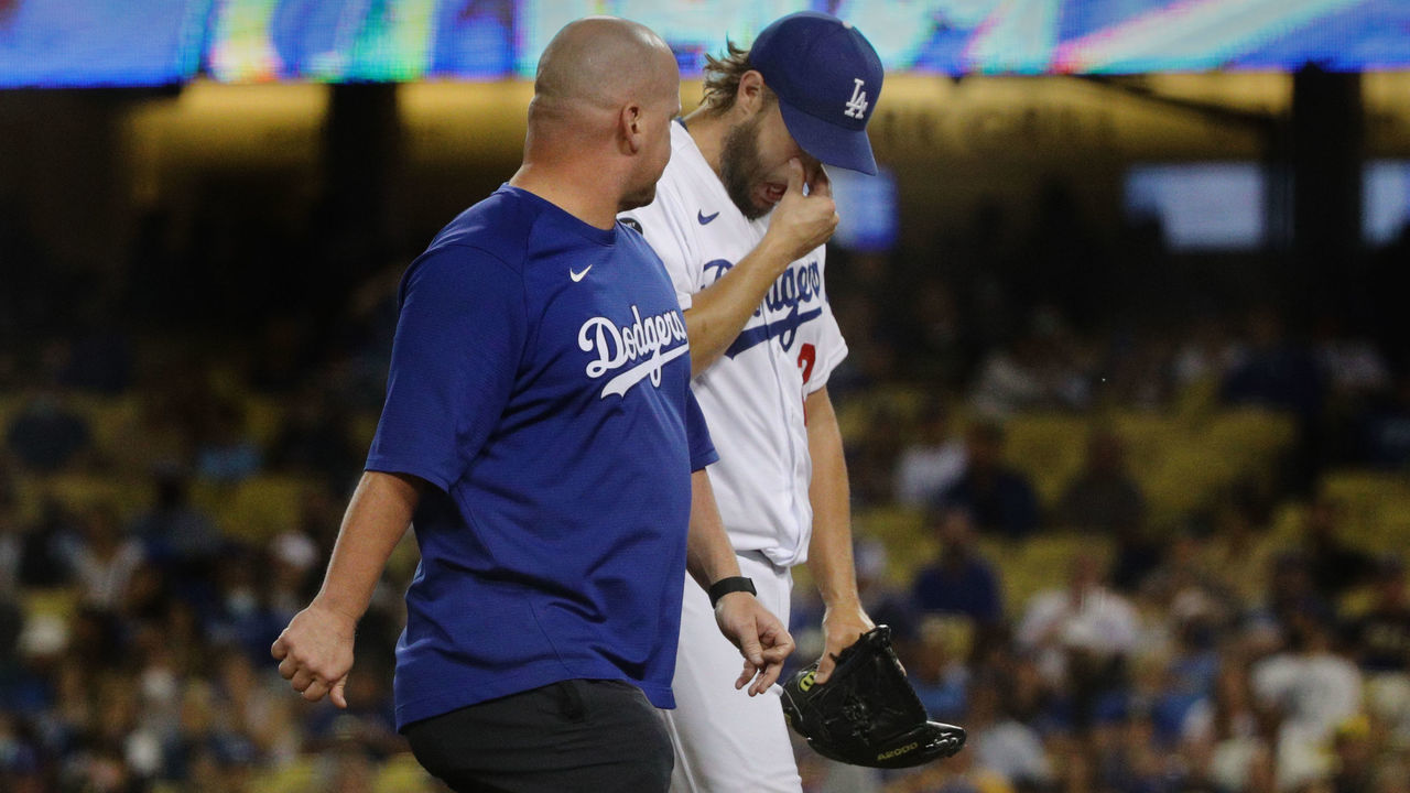 LOS ANGELES, CA - OCTOBER 1, 2021: Los Angeles Dodgers starting pitcher Clayton Kershaw (22) walks off the field with a trainer after being removed from the game with two outs in the second inning with the Milwaukee Brewers leading 3-1 at Dodger Stadium on October 1, 2021 in Los Angeles, California.(Gina Ferazzi / Los Angeles Times via Getty Images)
