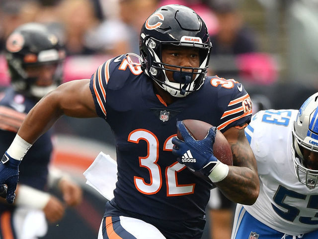 CHICAGO, ILLINOIS - OCTOBER 03: David Montgomery #32 of the Chicago Bears runs with the ball away from Charles Harris #53 of the Detroit Lions in the first half at Soldier Field on October 03, 2021 in Chicago, Illinois.