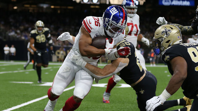 NEW ORLEANS, LOUISIANA - OCTOBER 03: Saquon Barkley #26 of the New York Giants is tackled by Pete Werner #20 of the New Orleans Saints during the first quarter at Caesars Superdome on October 03, 2021 in New Orleans, Louisiana.
