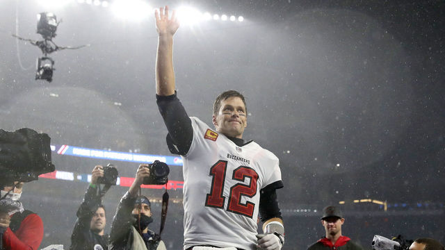 FOXBOROUGH, MASSACHUSETTS - OCTOBER 03: Tom Brady #12 of the Tampa Bay Buccaneers waves to the crowd as he runs off the field after defeating the New England Patriots in the game at Gillette Stadium on October 03, 2021 in Foxborough, Massachusetts.