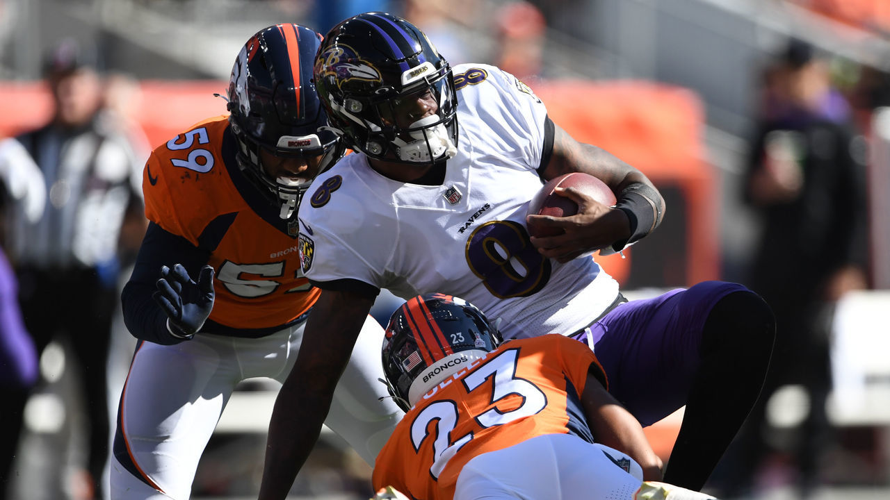 DENVER, COLORADO - OCTOBER 3: Denver Broncos cornerback Kyle Fuller (23), bottom, and his teammate Denver Broncos linebacker Malik Reed (59) hit Baltimore Ravens quarterback Lamar Jackson (8) on October 3, 2021 in Denver, Colorado. The Denver Broncos took on the Baltimore Ravens during week 4 of the 2021 NFL season at Empower Field at Mile High.