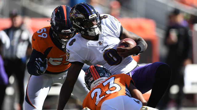 DENVER, COLORADO - OCTOBER 3: Denver Broncos cornerback Kyle Fuller (23), bottom, and his teammate Denver Broncos linebacker Malik Reed (59) hit Baltimore Ravens quarterback Lamar Jackson (8) on October 3, 2021 in Denver, Colorado. The Denver Broncos took on the Baltimore Ravens during week 4 of the 2021 NFL season at Empower Field at Mile High.