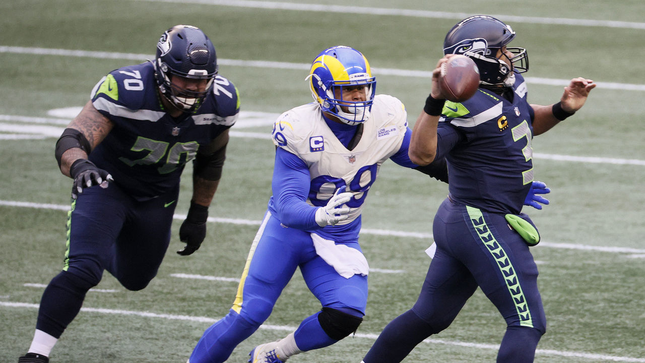 SEATTLE, WASHINGTON - JANUARY 09: Aaron Donald #99 of the Los Angeles Rams pressures Russell Wilson #3 of the Seattle Seahawks during the third quarter in an NFC Wild Card game at Lumen Field on January 09, 2021 in Seattle, Washington.
