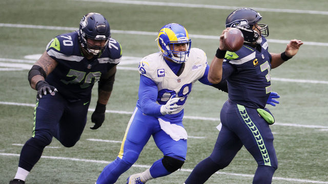 SEATTLE, WASHINGTON - JANUARY 09: Aaron Donald #99 of the Los Angeles Rams pressures Russell Wilson #3 of the Seattle Seahawks during the third quarter in an NFC Wild Card game at Lumen Field on January 09, 2021 in Seattle, Washington.