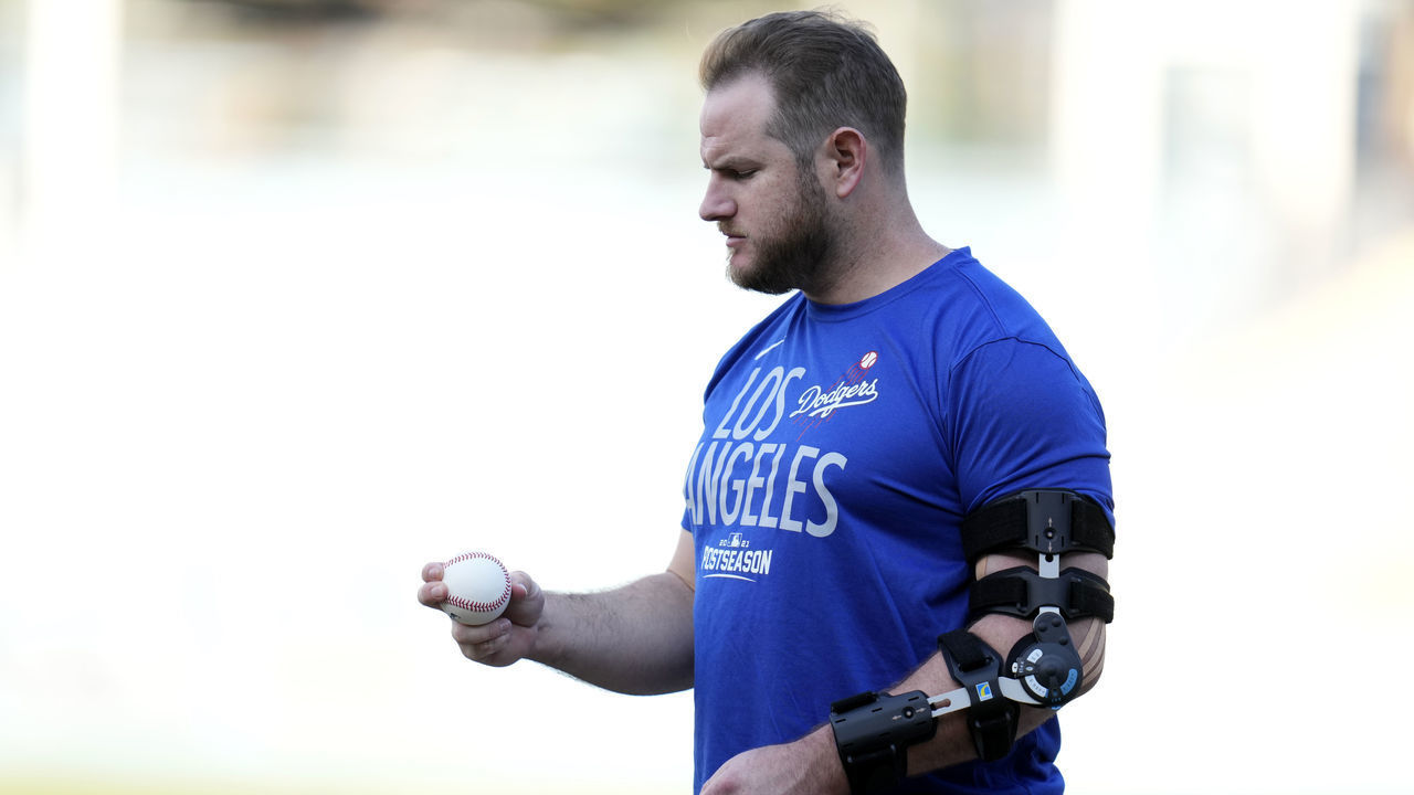 Los Angeles, CA - October 05: Max Muncy #13 of the Los Angeles Dodgers wearing a brace on his left arm looks at a baseball during a workout day before the National League Wildcard game against the St. Louis Cardinals at Dodger Stadium in Los Angeles on Tuesday, October 5, 2021.