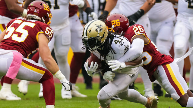 LANDOVER, MD - OCTOBER 10: New Orleans Saints running back Alvin Kamara (41) is tackled by Washington Football Team safety Landon Collins (26) and linebacker Cole Holcomb (55) during the first half at a NFL game between the Washington Football Team and the New Orleans Saints on October 10, 2021 at the FedExField in Landover, MD.