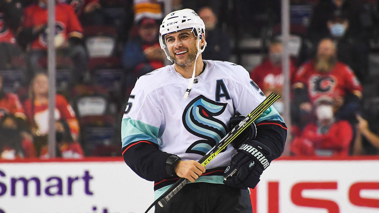 CALGARY, AB - SEPTEMBER 29: Mark Giordano #5 of the Seattle Kraken smiles as he takes his broken stick back to the bench after taking his shot in a shootout against the Calgary Flames during an NHL game at Scotiabank Saddledome on September 29, 2021 in Calgary, Alberta, Canada.