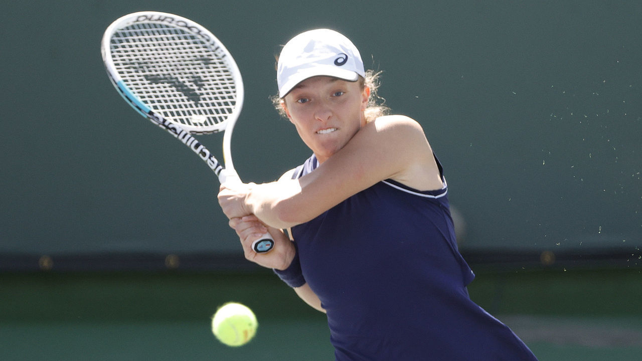INDIAN WELLS, CALIFORNIA - OCTOBER 12: Iga Swiatek of Poland returns a shot to Jelena Ostapenko of Latvia during the BNP Paribas Open at the Indian Wells Tennis Garden on October 12, 2021 in Indian Wells, California.