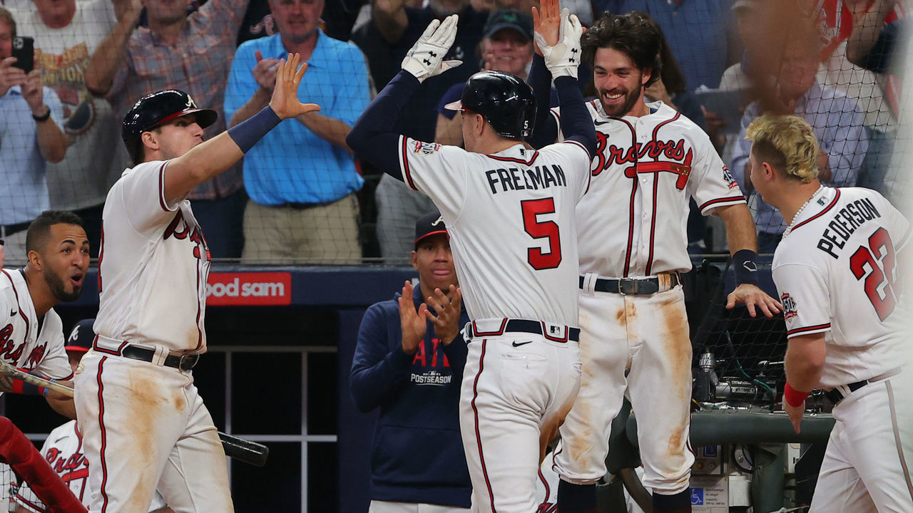 ATLANTA, GEORGIA - OCTOBER 12: Freddie Freeman #5 of the Atlanta Braves high fives Austin Riley #27 and Dansby Swanson #7 after hitting a home run during the eighth inning against the Milwaukee Brewers in game four of the National League Division Series at Truist Park on October 12, 2021 in Atlanta, Georgia.