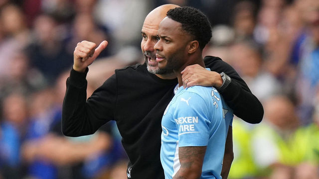 LONDON, ENGLAND - SEPTEMBER 25: Pep Guardiola, Manager of Manchester City speaks with player Raheem Sterling during the Premier League match between Chelsea and Manchester City at Stamford Bridge on September 25, 2021 in London, England.